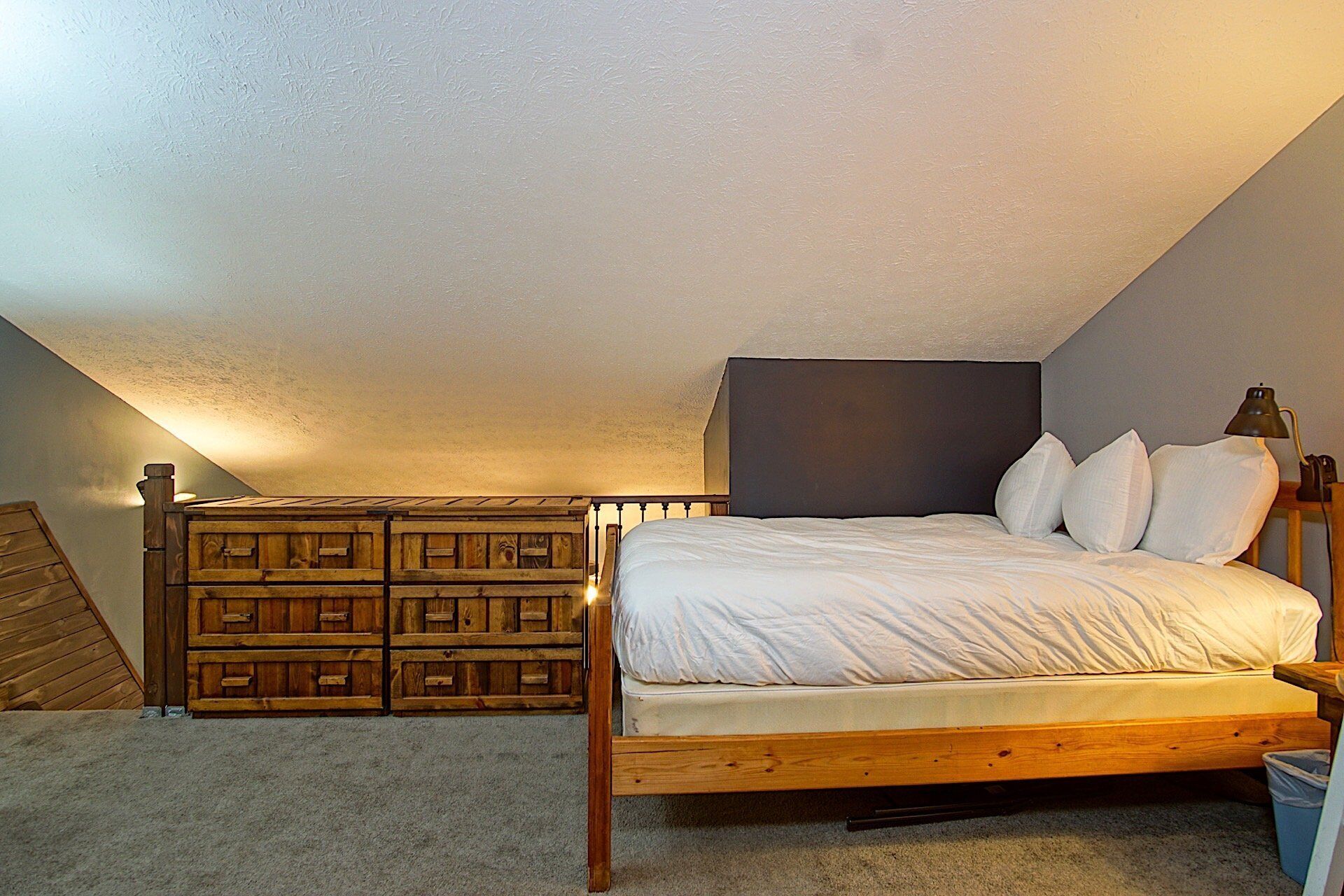 A bedroom with a wooden bed, a headboard, and a built-in wooden storage unit.