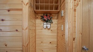 Eine Holzhütte mit Kamin, einer dekorativen Adventskrans und Handschuhen an der Wand.