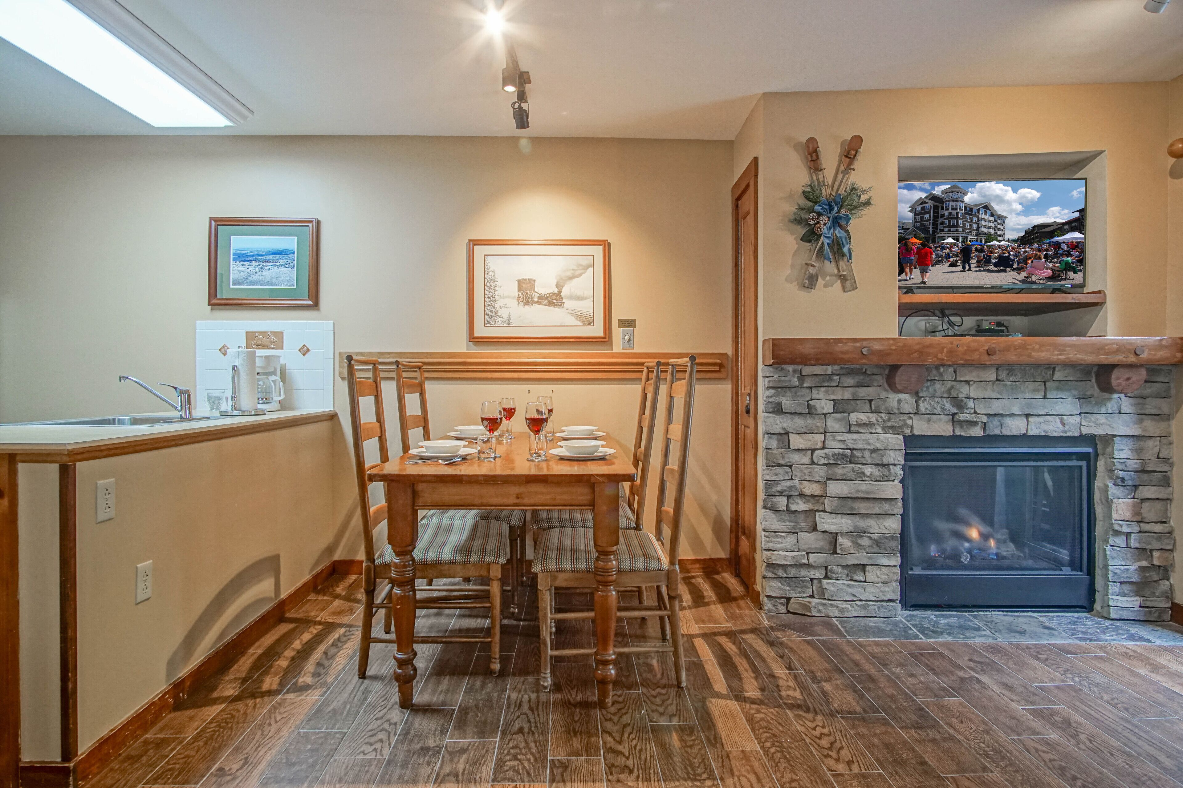 A dining area with a stone fireplace, wooden dining table, and chairs.