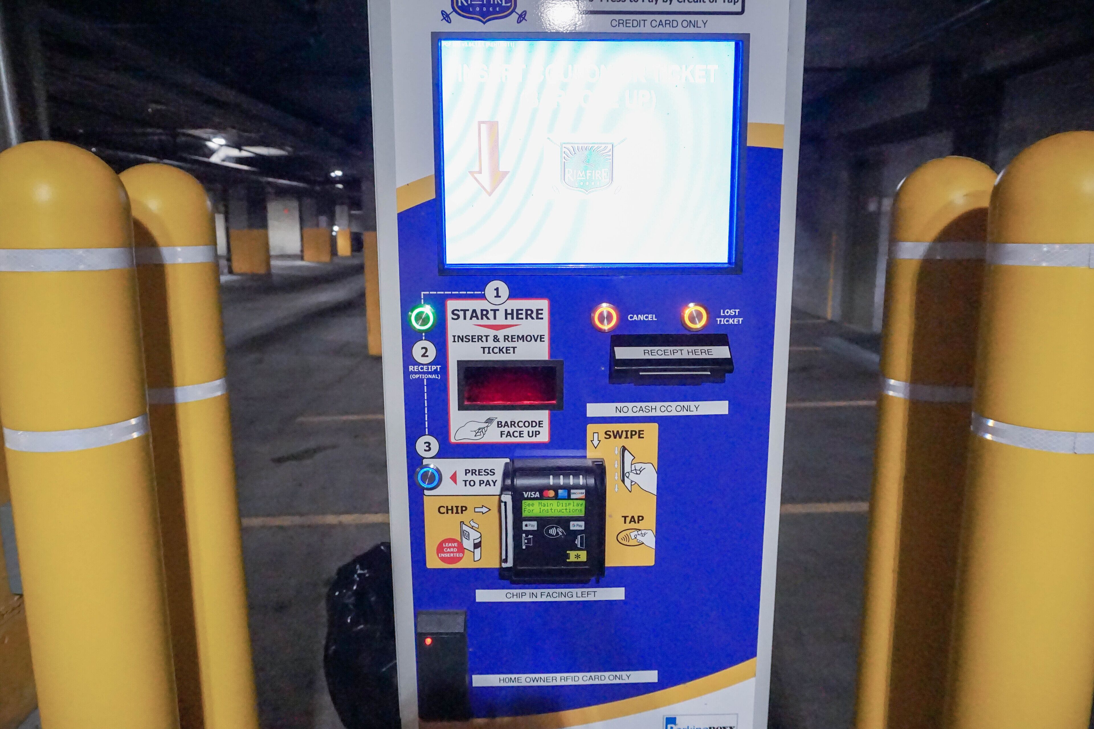 Parcometro con istruzioni per i metodi di pagamento, tra cui un lettore di chip, una tastiera e uno scanner di codici a barre.