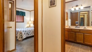 Ein Schlafzimmer mit einem Bett, einer Nachttischlampe und einem Fenster mit Jalousien.