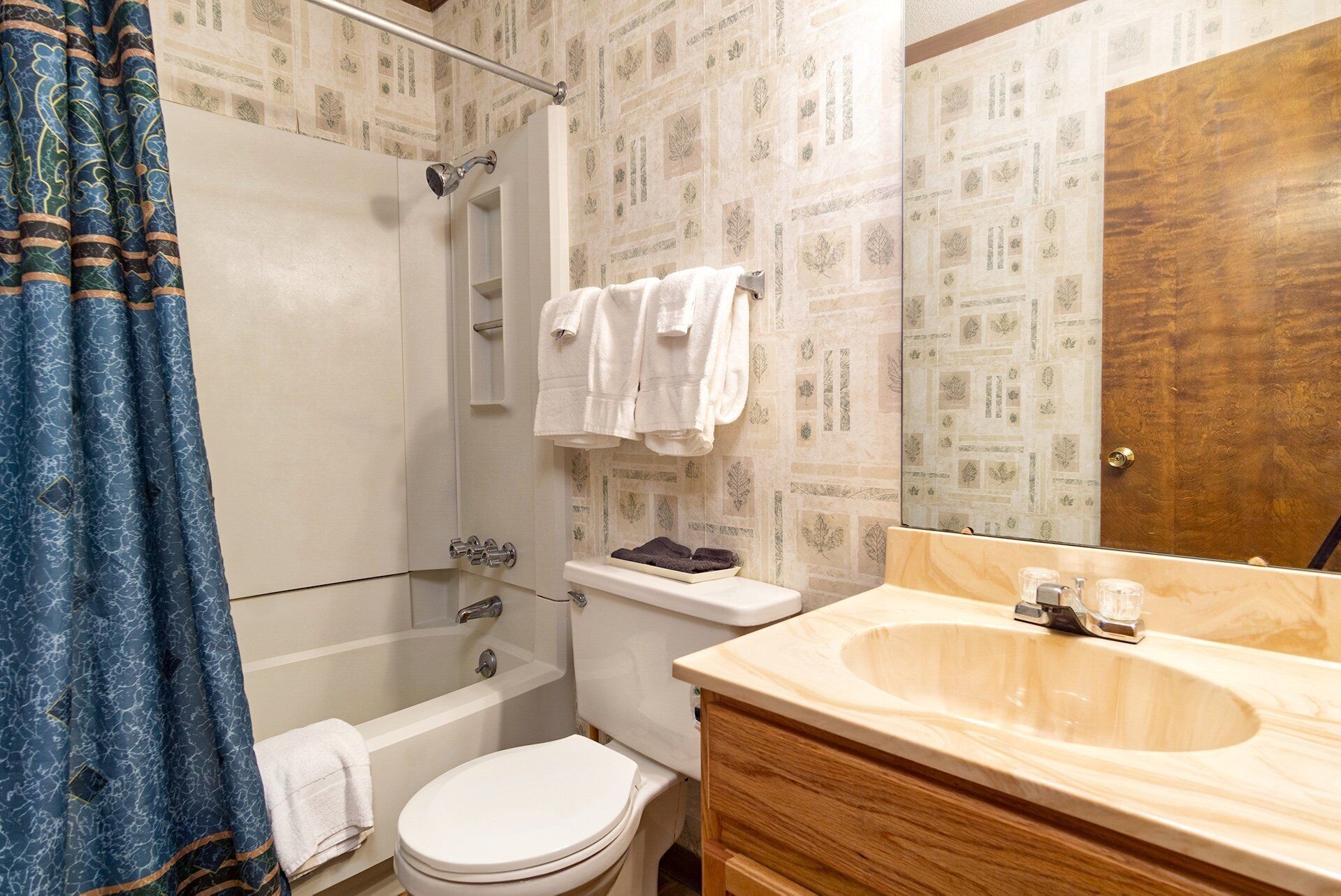 A bathroom with a bathtub, toilet, and vanity with a sink.