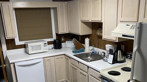 Cocina compacta con microondas, tostadora, lavabo y refrigerador.