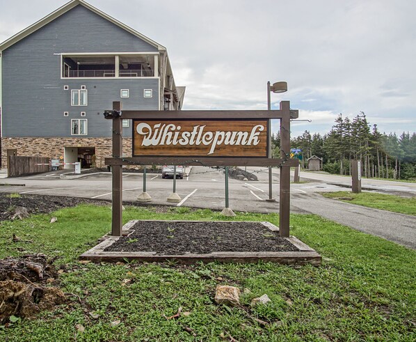 Une enseigne indiquant l’emplacement de Whistlepunk, avec un bâtiment visible en arrière-plan.