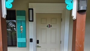 A wooden door with a number 3 sticker, a teal door knocker, and a black doormat. - 103 Classic Studio Suite in waterfront hotel in Singer Island, FL (Riviera Beach)