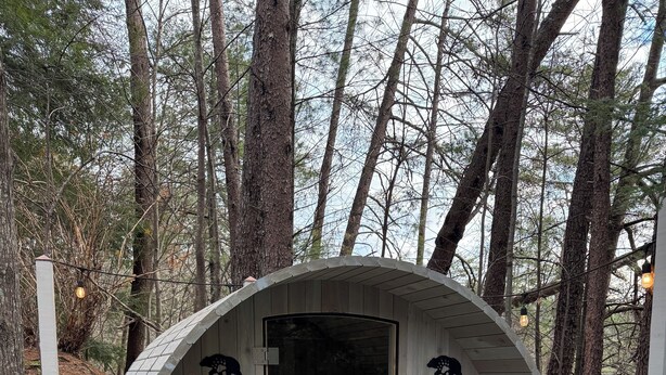 A wooden sauna with a glass door, benches inside, and a wooden bench outside. - Stargazer Cabin: Sauna, Rooftop Deck, Fire Pit, Indoor Wood Fireplace, Privacy (Blue Ridge)