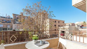 Ein Balkon mit Tisch, Stühlen und einem Blumentopf.