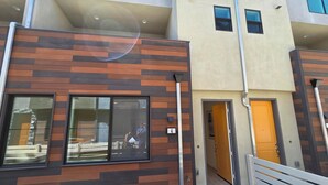 A modern building with a wooden facade, large windows, and a visible door. - Spacious 4-bedroom townhome in beautiful Long Beach with AC (Long Beach)