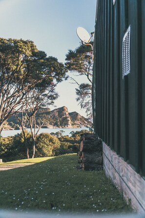 Un bâtiment doté d’une antenne parabolique, d’une zone herbeuse et d’arbres.