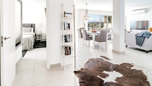 Ein modernes Wohnzimmer mit Essbereich, einer Bücherwand und Blick auf die Stadt.