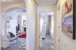 A spacious living area with a modern sofa, a red rug, and a television. - Saa2- Comfortable Apartment Puerto Banus (Marbella)