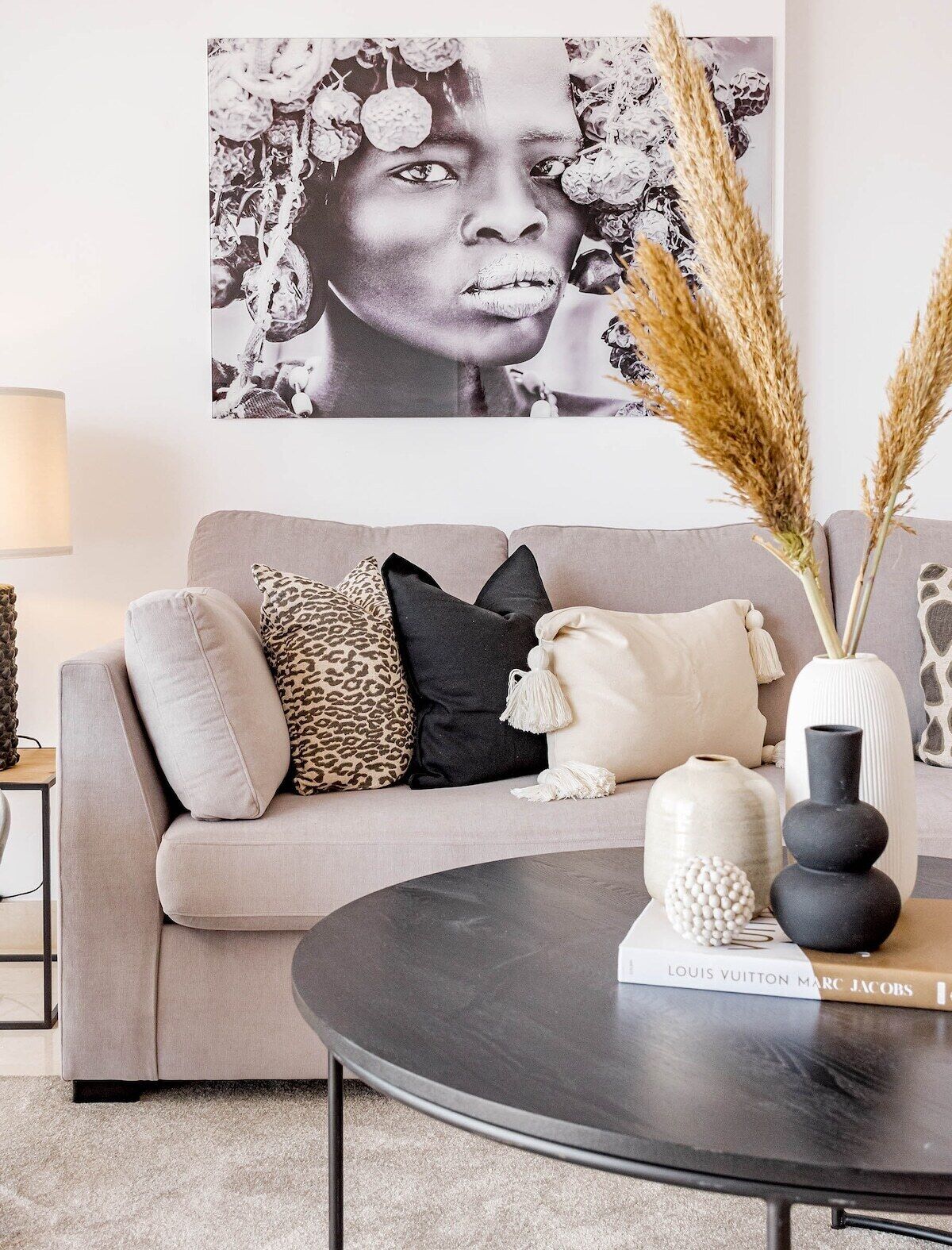 A living room with a sofa, pillows, a coffee table, and decorative items including a vase and a book.