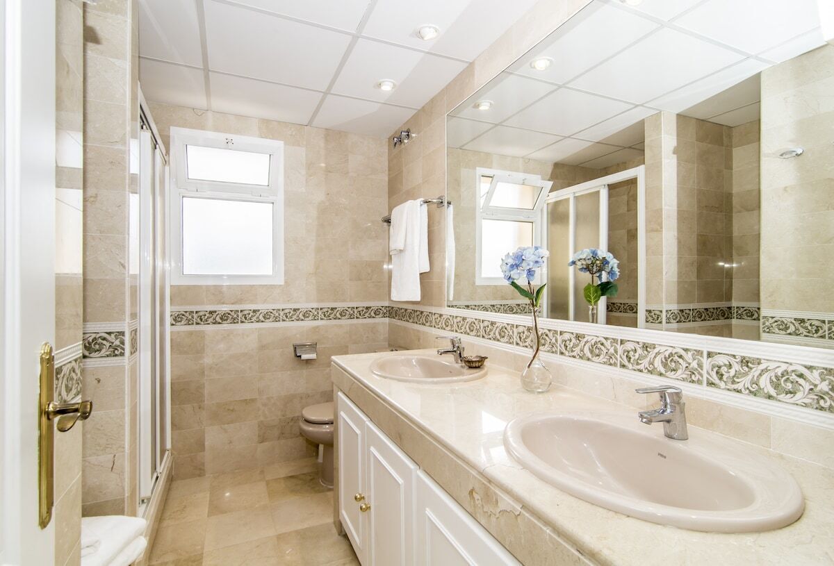 Ein Badezimmer mit zwei Waschbecken, einer Toilette und einer Dusche.