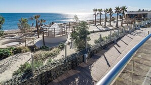 A coastal promenade with a circular viewing platform, palm trees, and a beach. - TE- Luxury Resort, Front Line Beach, Families Only (Estepona)