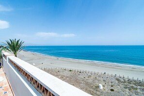 A coastal view from a balcony overlooking a beach with a clear sky. - Lap- 3 bed Apartment on the Beach. Families Only (Casares)