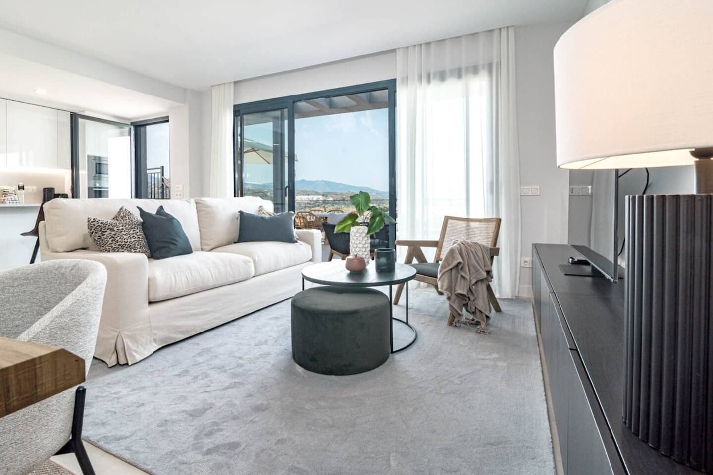 A modern living room with a sofa, a round coffee table, and a television.