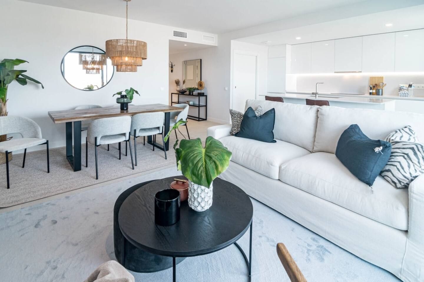 A modern living room with a sofa, coffee table, and dining area.