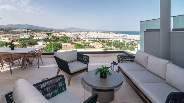 A terrace with a sofa, chairs, and a table, overlooking a cityscape and mountains. - Lme9f1- Penthouse, Amazing Views, Families Only (Estepona)