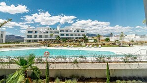 A modern hotel with a pool, white buildings, and a clear blue sky. - Lm352b- Spacious Duplex Penthouse With Panoramic (Estepona)