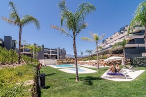 Un resort con piscina, palmeras y edificios modernos.