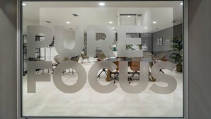 Un espacio de oficina moderno con un amplio ventanal que muestra la frase 'PURE FOCUS'.
