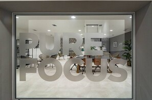 Un espacio de oficina moderno con un amplio ventanal que muestra la frase 'PURE FOCUS'.