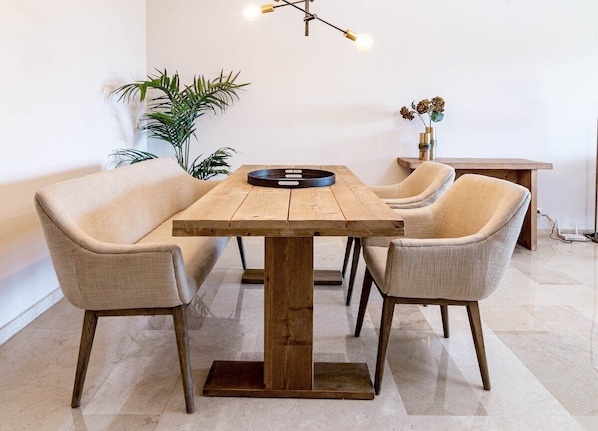 A dining area with a wooden table and four chairs, a hanging light fixture, and a potted plant. - Ma7b-stunning Holiday Home top Location (Marbella)