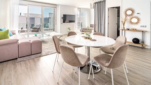 A modern living room with a round dining table, beige chairs, a pink sofa, and a glass coffee table. - Lm111a- Modern Flat, Amazing Views (Estepona)