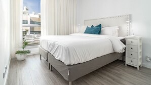A modern bedroom with a large bed, a bedside table, and a potted plant. - Lm111a- Modern Flat, Amazing Views (Estepona)