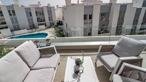 A rooftop terrace with a pool, white furniture, and a view of modern buildings. - Lm111a- Modern Flat, Amazing Views (Estepona)
