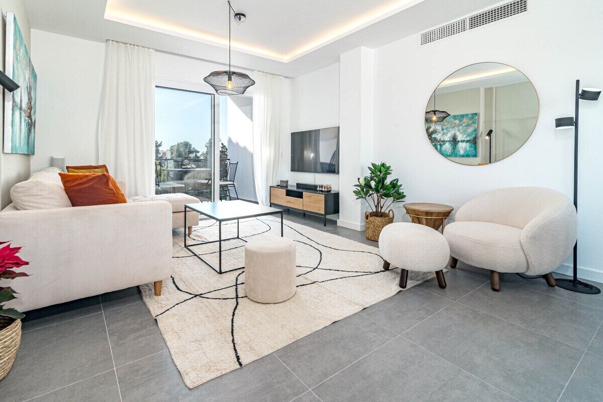 Un salon moderne comprenant un canapé, un fauteuil, une table basse et un grand miroir.