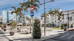 Una escena callejera con una señal de prohibido el paso, una señal de dirección y una señal de estacionamiento.