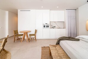 A compact hotel room with a kitchenette, a dining area, and a bed. - A5- Seaclub Suites by Roomservices (Estepona)
