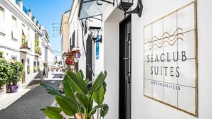 Een smalle straat met een gebouw waarop staat: 'SEACLUB SUITES BYROOMSERVICES'.