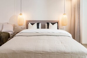 A hotel room with a large bed, two bedside lamps, and a nightstand. - A1- Seaclub Suites by Roomservices (Estepona)