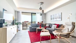 A modern living room with a grey sofa, red rug, and a wooden cabinet. - Inf46p - Spacious Holiday Home in Estepona (Estepona)