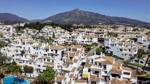 A coastal residential area with white buildings, a mountain in the background, and a swimming pool. - AB4 - Lovely Holiday Home Walking Distance, Beach (Marbella)