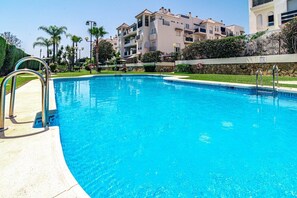 A swimming pool with metal railings, surrounded by a stone wall and greenery. - Lcr1- Lovely Ground Floor Apartment, Puerto Banus (Marbella)