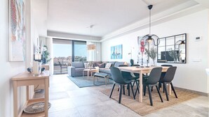 Una sala de estar moderna con comedor, ventanas amplias y vistas a la ciudad.