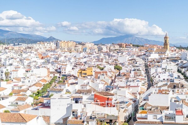 A densely packed urban area with white buildings and a prominent tower. - Inf26f - Modern and Bright City Apartment (Estepona)