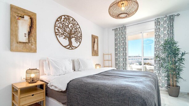 A bedroom with a bed, bedside tables, a hanging light fixture, a potted plant, and a window with curtains. - Lcr4 - Large 3-bedroom Apartment Near Beach (Marbella)