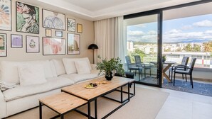 Un salon moderne avec un canapé, une table basse et des œuvres d’art accrochées au mur.