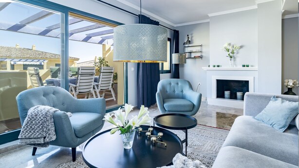 Ein modernes Wohnzimmer mit großem Fenster, Kamin und rundem Couchtisch.