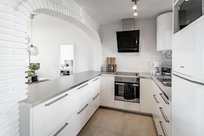 A modern kitchen with white cabinetry, a built-in oven, and a stainless steel refrigerator. - RDM - Stylish Holiday Apartment With Ocean Views (Mijas)