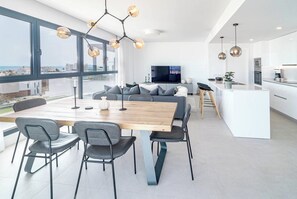 A modern kitchen with a dining area, large windows, and a city view. - Lme103a - Bright Modern Flat With Amazing Terrace (Estepona)