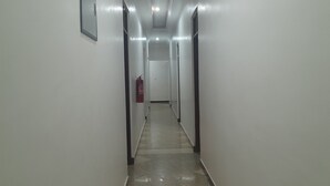 A long, narrow hallway with white walls and a tiled floor. - DAG HOTEL MOROGORO (Morogoro)