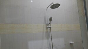 A shower area with a handheld showerhead and a fixed showerhead. - DAG HOTEL MOROGORO (Morogoro)