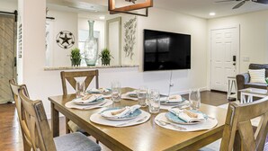 Comedor con una mesa de madera dispuesta para seis personas, rodeado de sillas.