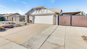 A residential house with a garage, a driveway, and a gated entrance. - Private Pool & Fenced Yard: Sunny Glendale Getaway (Glendale)