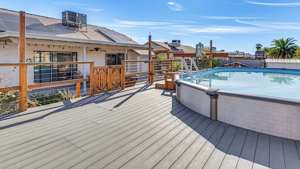 A rooftop pool area with a wooden deck, a hot tub, and a view of the surrounding buildings. - Private Pool & Fenced Yard: Sunny Glendale Getaway (Glendale)